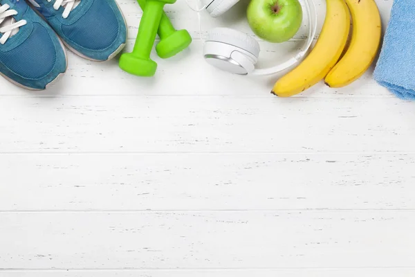 ダンベルと木製のテーブルの上の果物とヘッドフォンとスニーカー 上面ビュー フィットネス 健康食品のコンセプト — ストック写真