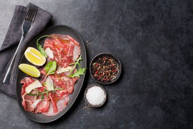 Mermer Dana carpaccio roka, limon ve Parmesan peyniri ile