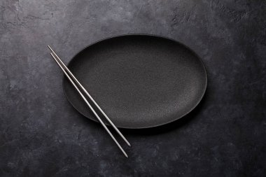 Boş levha ve chopsticks siyah dokulu tablo üzerinde
