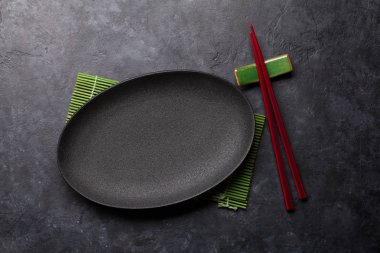 Boş levha ve chopsticks siyah dokulu tablo üzerinde