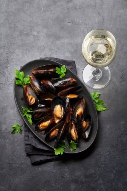 Lezzetli deniz ürünleri sos domates, maydanoz ve şarap taş zemin üzerine midye pişmiş. 