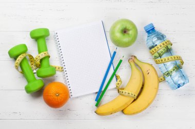 Halter, meyve, bir şişe su ve ahşap masa üstünde not etmek