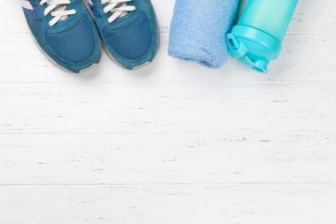 Spor ayakkabı, ahşap masa havlu ve içki şişesinde