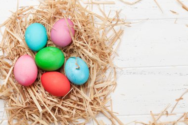 Paskalya tebrik kartı Velur üzerinde renkli yumurta ile ahşap arka plan üzerinde çimenler 