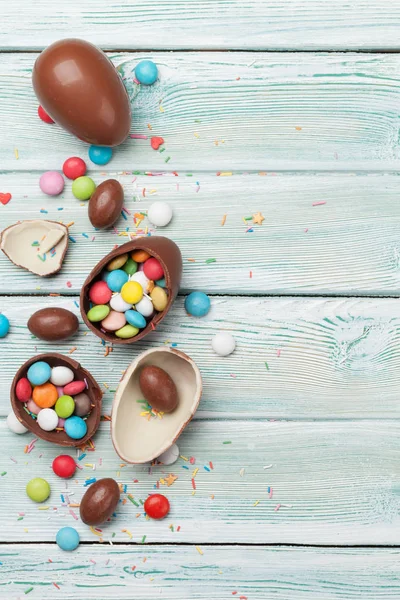 复活节贺卡与巧克力蛋和五颜六色的糖果在木背景 — 图库照片
