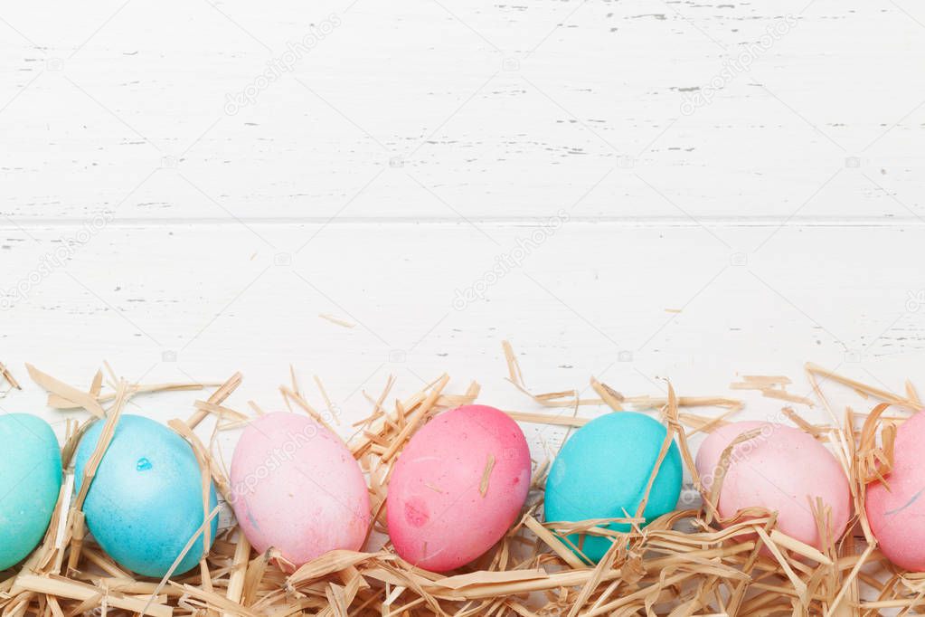 Easter greeting card with colorful eggs on wooden background 