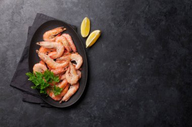 Buğulanmış kaplan karides maydanoz ve limon dilimleri ile