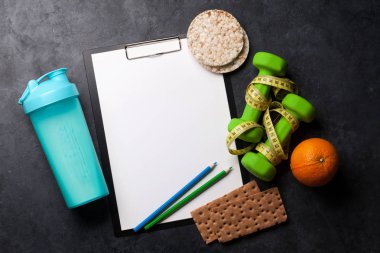 Halter, içki şişesi, granola ve taş masada şerit metre