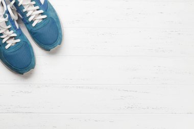 Beyaz ahşap zemin üzerinde mavi ayakkabı