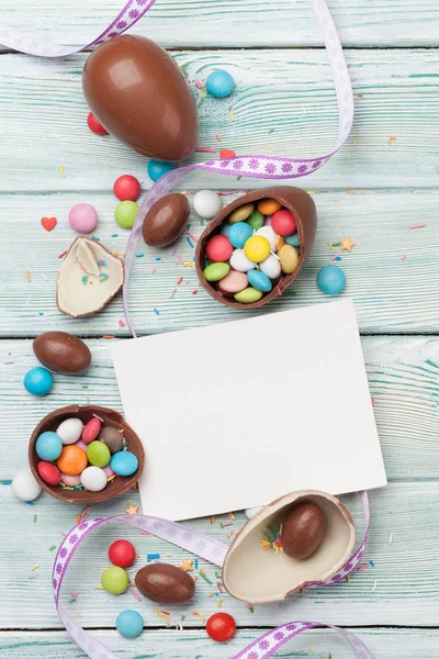 复活节贺卡与巧克力蛋和五颜六色的糖果在木背景 — 图库照片