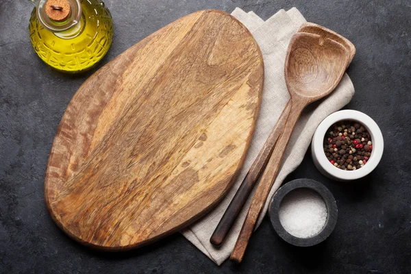 木製調理器具 まな板 黒い石の背景にスパイスを料理 — ストック写真