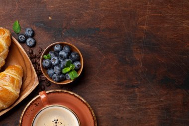 Koyu ahşap masa kahve, kruvasan ve çilek görünümü kapat 