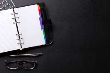 Siyah masada Not defteri ve dizüstü bilgisayar ile ofis çalışma masası