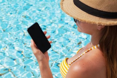 Yüzme Havuzu Smartphone kullanan genç kadın