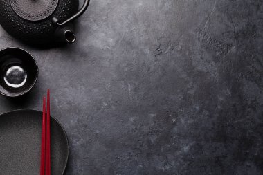 Boş levha, kupa, çaydanlık ve çubuk siyah dokulu tablo üzerinde