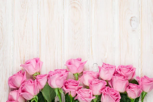 Rosa Rosen über Holztisch — Stockfoto