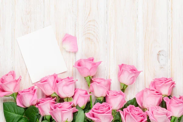 Roze rozen over houten tafel — Stockfoto