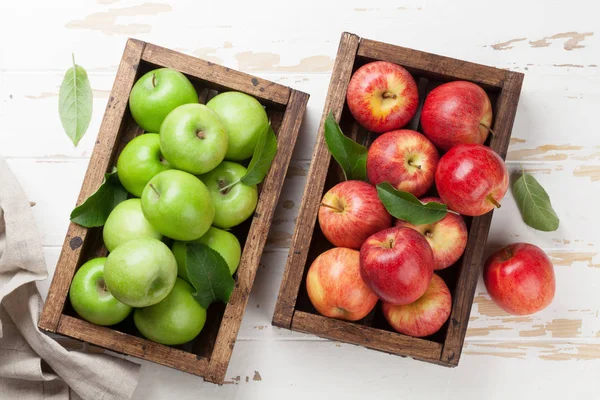Зеленые и красные яблоки в деревянной коробке — стоковое фото