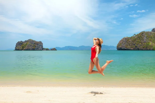 Jovem mulher atraente pulando na praia do mar — Fotografia de Stock