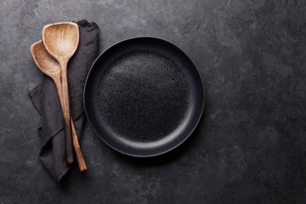 Kochutensilien aus Holz und leerer Teller — Stockfoto