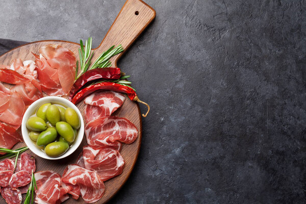 Traditional spanish jamon, prosciutto crudo, italian salami, parma ham with green olives 