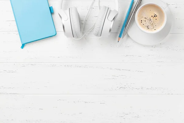 Kahve fincanı, kulaklık ve sarf malzemeleri ile ofis masası — Stok fotoğraf