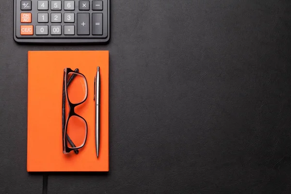 Mesa de escritório com óculos, suprimentos e calculadora — Fotografia de Stock