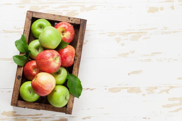 Pommes vertes et rouges dans une boîte en bois — Photo