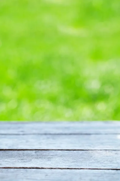 Lege houten tafel over bokeh natuurlijke achtergrond — Stockfoto