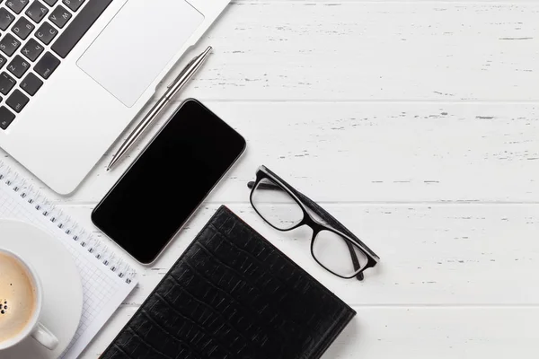 Tavolo da lavoro ufficio con smartphone, occhiali e forniture — Foto Stock