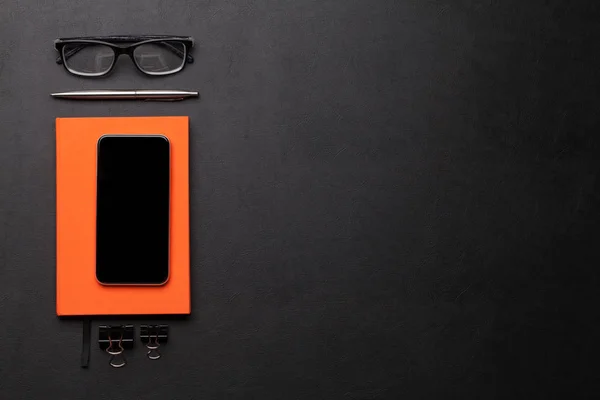 Mesa de oficina con smartphone, gafas y suministros — Foto de Stock