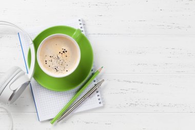 Kahve fincanı, kulaklık ve sarf malzemeleri ile ofis masası