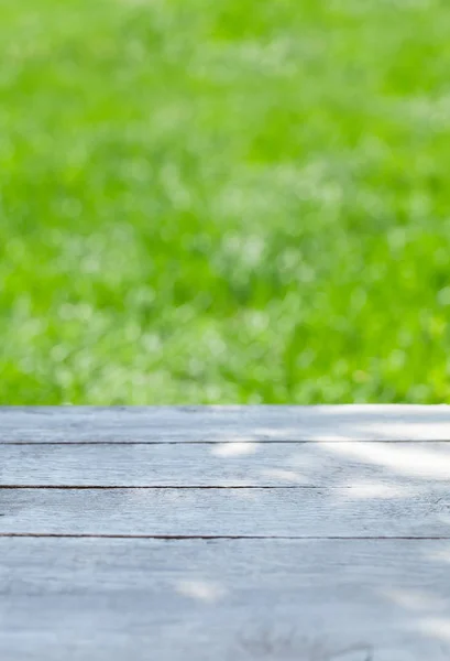 Lege houten tafel over bokeh natuurlijke achtergrond — Stockfoto