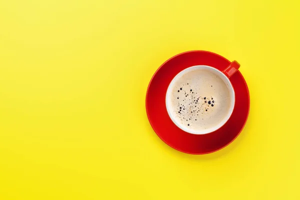 黄色の背景の上に赤いコーヒーカップ — ストック写真
