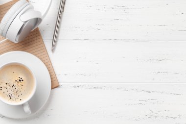 Kahve bardağı, kulaklık ve sarf malzemeleri ile ofis masası