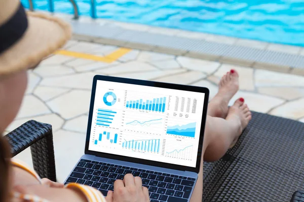Giovane donna che utilizza il computer portatile vicino a una piscina — Foto Stock