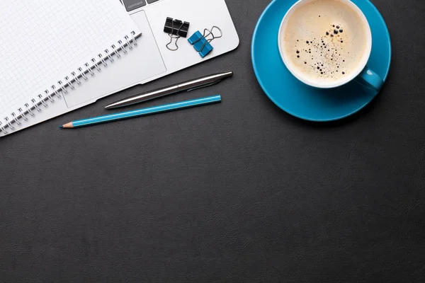 Kontorsbord med kaffe, förbrukningsmaterial och dator — Stockfoto