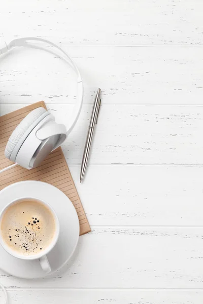 Mesa de oficina con taza de café, auriculares y suministros — Foto de Stock