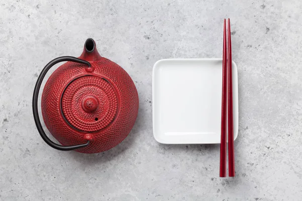 Assiette vide, tasse, théière et baguettes — Photo