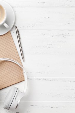 Kahve bardağı, kulaklık ve sarf malzemeleri ile ofis masası