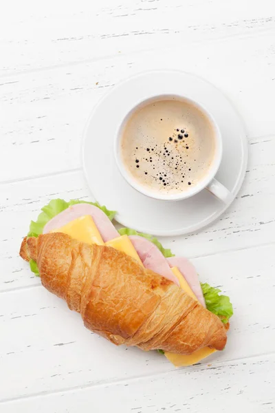 Coffee and croissant sandwich