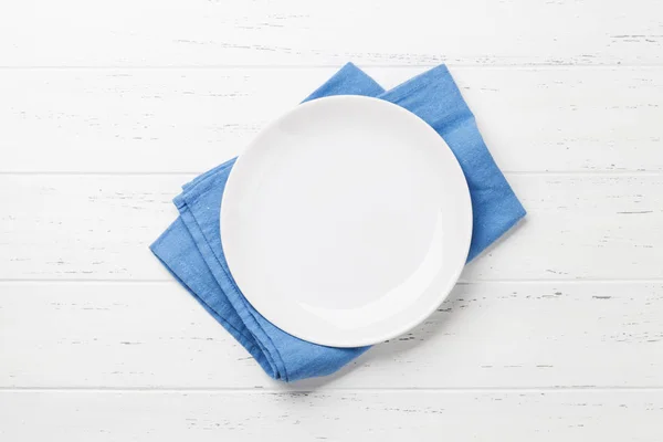 Empty plate on wooden kitchen table — Stock Photo, Image