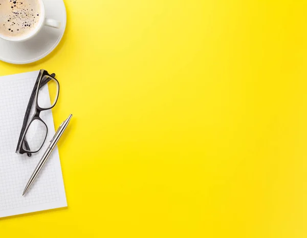 Büro gelb Hintergrund mit Kaffee und Vorräten — Stockfoto