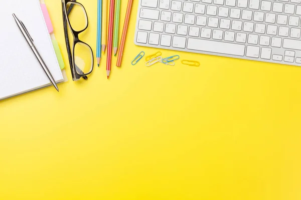 Fondo amarillo de oficina con suministros y computadora — Foto de Stock