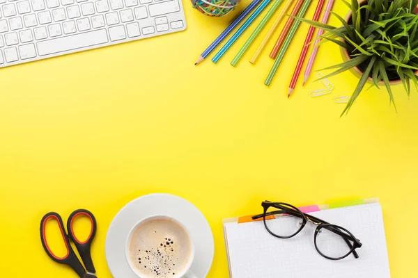 Escritório fundo amarelo com café, suprimentos e computador — Fotografia de Stock