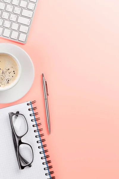 Office roze achtergrond met koffie, benodigdheden en computer — Stockfoto