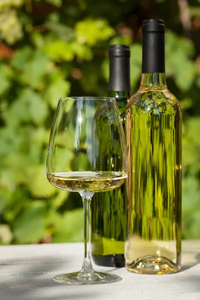 Beyaz şarap şişeleri ve şarap kadehi — Stok fotoğraf