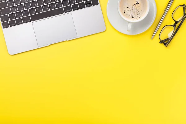 Oficina lugar de trabajo amarillo con taza de café, suministros y computadora — Foto de Stock