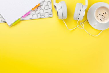 Kahve, kulaklık ve bilgisayar ile ofis sarısı arka plan