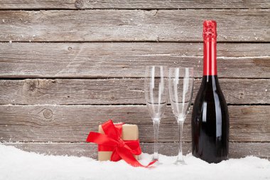 İçinde şampanya ve hediye kutusu olan bir Noel kartı.